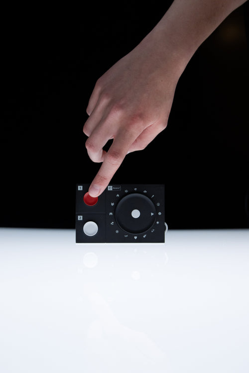 Finger pressing the red button on the NTS Radio Player
