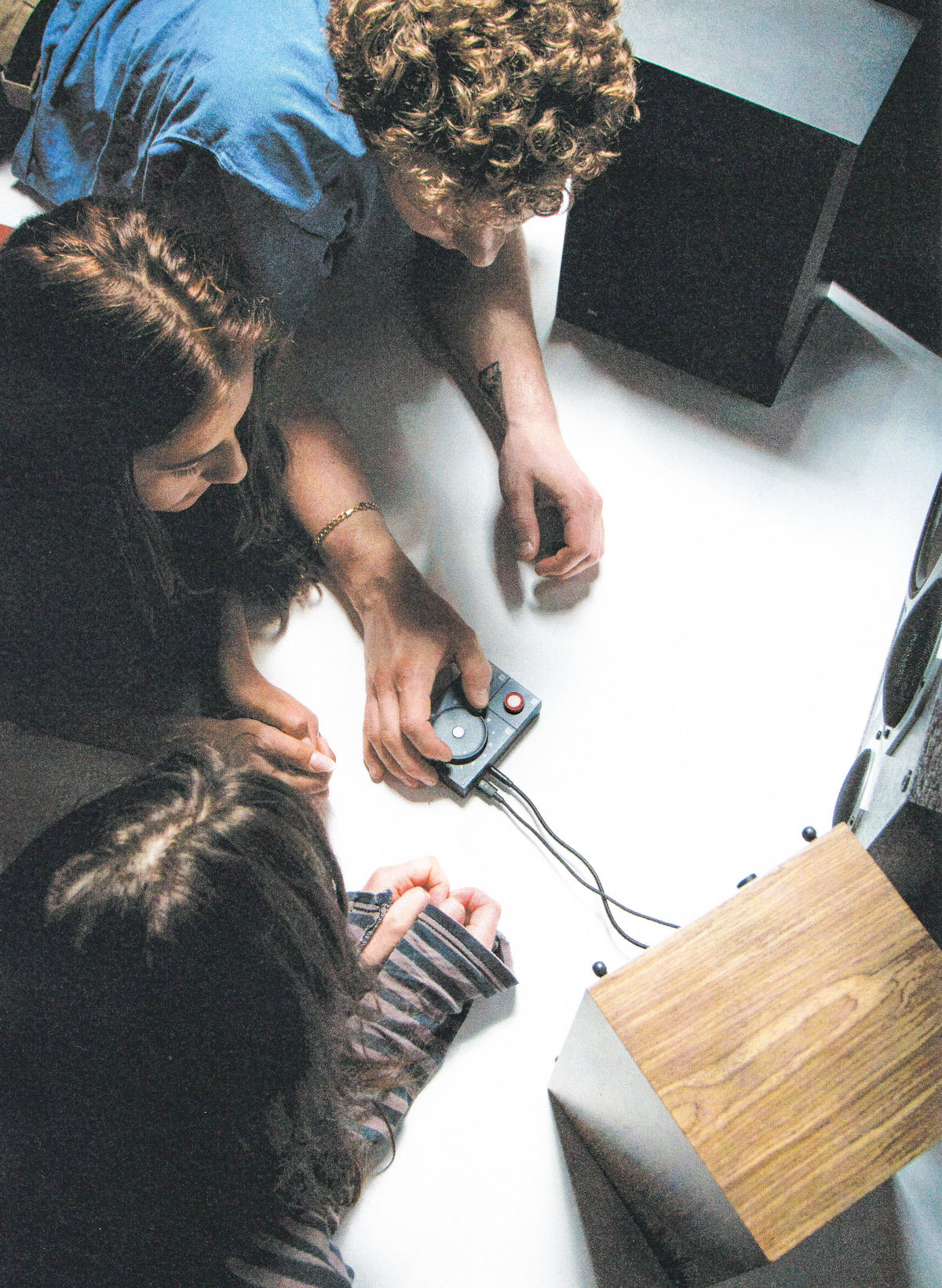 Two people using the NTS Radio Player on the floor