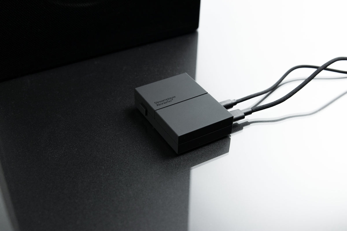 Streamplayer on a dark table next to a speaker