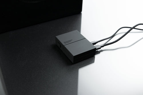 Streamplayer on a dark table next to a speaker